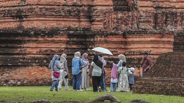Sejumlah wisatawan mengunjungi Candi Tinggi dalam Kawasan Cagar Budaya Nasional (KCBN) Muarajambi di Muaro Jambi, Jambi, Kamis (26/12/2024). Kawasan situs cagar budaya yang diperkirakan dibangun pada abad ke-6 dan menjadi kawasan pendidikan Buddha terbesar di Asia Tenggara atau seluas 3.981 hektare itu menjadi pilihan sebagian warga untuk memanfaatkan waktu libur Natal 2024 dan Tahun Baru 2025 dengan kunjungan rata-rata per hari 500 orang lebih. ANTARA FOTO/Wahdi Septiawan/YU