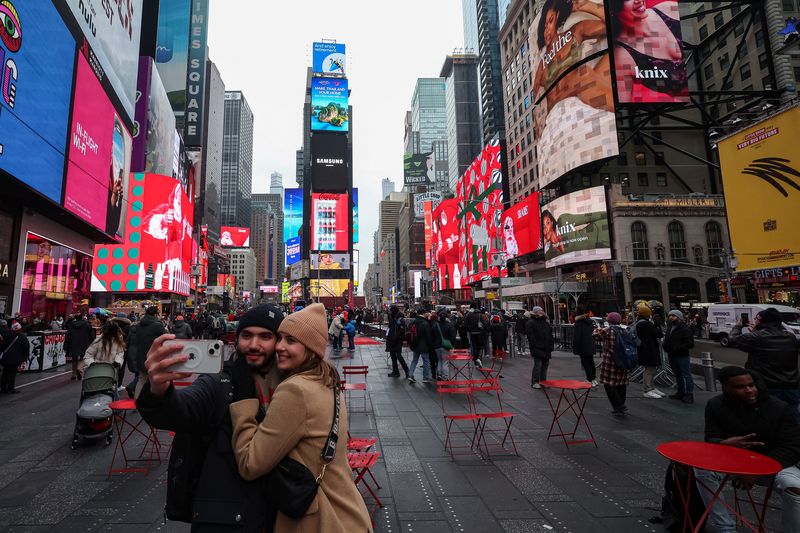 People take a selfie in Times Square in Manhattan in New York City, U.S., December 24, 2024. REUTERS/Marko Djurica