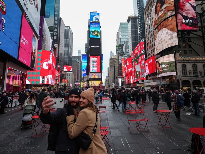 People take a selfie in Times Square in Manhattan in New York City, U.S., December 24, 2024. REUTERS/Marko Djurica