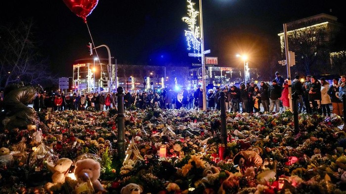 Lautan Bunga Kenang Korban Serangan Pasar Natal di Jerman People attend an AfD election campaign in near the Christmas Market in Magdeburg, Germany, Monday, Dec. 23, 2024. (AP Photo/Ebrahim Noroozi)