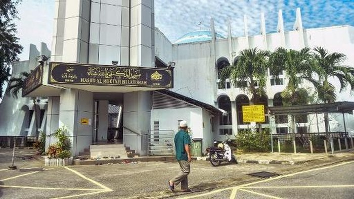A man walks past Masjid Al-Muktafi Billah Shah mosque in Kuala Terengganu on December 27, 2024. A man was flogged inside a Malaysia mosque on December 27 after being convicted of an Islamic offence for spending time alone with a woman who was neither his wife or relative, state news said. (Photo by ARIF KARTONO / AFP)