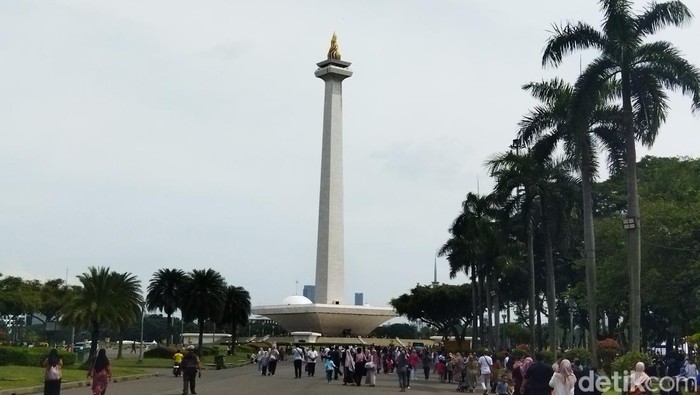 Para pengunjung sudah mulai terlihat ramai sejak dari parkiran. Mereka pun tampak ramai-ramai berjalan ke arah pintu masuk Monas. Foto: Fadil/detikcom