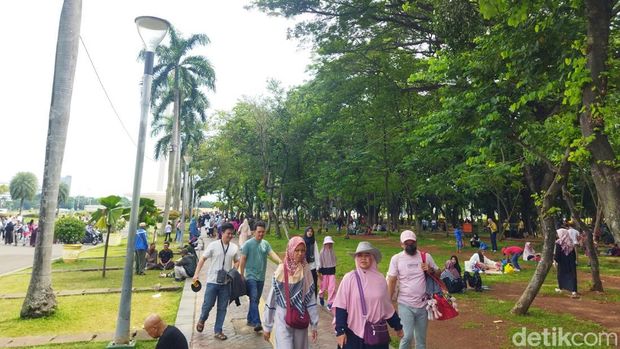 Para pengunjung sudah mulai terlihat ramai sejak dari parkiran. Mereka pun tampak ramai-ramai berjalan ke arah pintu masuk Monas. Foto: Fadil/detikcom