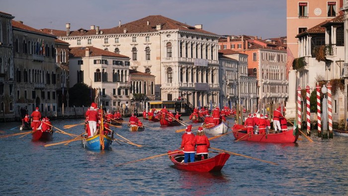 People dressed as Santa Claus row during a Christmas regatta along the Grand Canal in Venice, Italy, December 22, 2024. REUTERS/Manuel Silvestri     TPX IMAGES OF THE DAY
