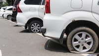 Sejumlah kendaraan yang telah dikempiskan bannya karena melanggar peraturan parkir di Jalan Medan Merdeka Selatan, kawasan Monumen Nasional (Monas), Jakarta, Minggu (29/12/2024). 