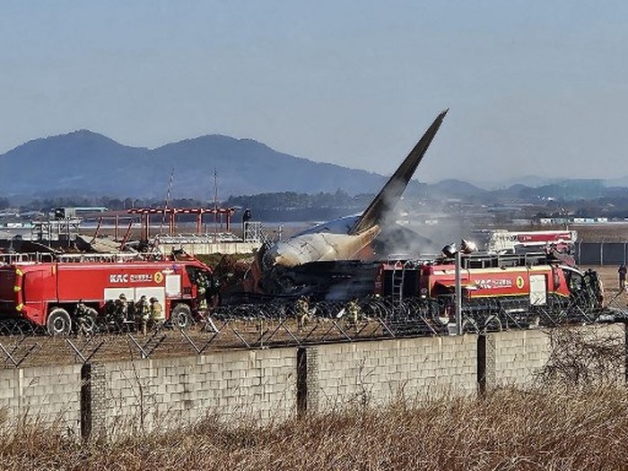 The tail section of a Jeju Air Boeing 737-800 series aircraft is seen beside rescue vehicles after the plane crashed and burst into flames at Muan International Airport in South Jeolla Province, some 288 kilometres southwest of Seoul on December 29, 2024. A Jeju Air plane carrying 181 people from Bangkok to South Korea crashed on arrival on December 29, authorities told AFP, with 29 confirmed dead and dramatic video showing the aircraft bursting into flames. (Photo by YONHAP / AFP) / - South Korea OUT / NO ARCHIVES -  RESTRICTED TO SUBSCRIPTION USE