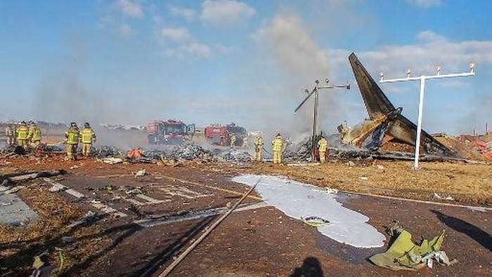 The tail section of a Jeju Air Boeing 737-800 series aircraft is seen beside rescue personnel after the plane crashed and burst into flames at Muan International Airport in South Jeolla Province, some 288 kilometres southwest of Seoul on December 29, 2024. A Jeju Air plane carrying 181 people from Bangkok to South Korea crashed on arrival on December 29, authorities told AFP, with 29 confirmed dead and dramatic video showing the aircraft bursting into flames. (Photo by YONHAP / AFP) / - South Korea OUT / NO ARCHIVES - RESTRICTED TO SUBSCRIPTION USE