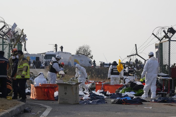 Firefighters and rescue team members work near the wreckage of a passenger plane at Muan International Airport in Muan, South Korea, Sunday, Dec. 29, 2024. (AP Photo/Ahn Young-joon)