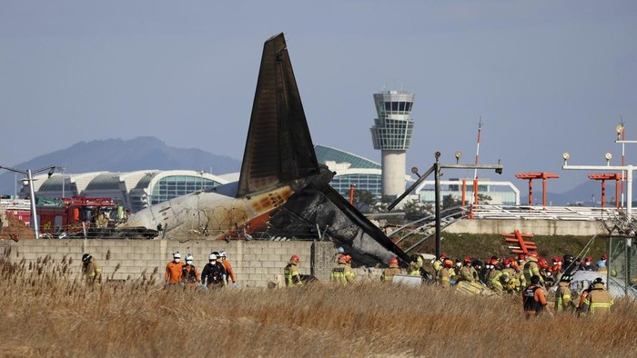 Firefighters and rescue team members work near the wreckage of a passenger plane at Muan International Airport in Muan, South Korea, Sunday, Dec. 29, 2024. (AP Photo/Ahn Young-joon)