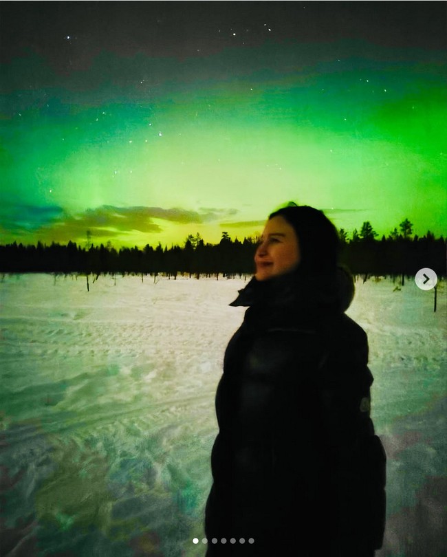 Jaket tebal jadi pilihan Rossa saat berpose dengan latar belakang aurora borealis di kawasan Rovaniemi, Finlandia yang suhunya bisa mencapai minus. Foto: Dok. Instagram Rossa