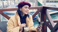 Gaya Thalita ketika berpose di sebuah kafe dengan pemandangan cantik. Ia menikmati kopi itu ketika berada di Venice, Italia. Foto: Instagram @thalitalatief