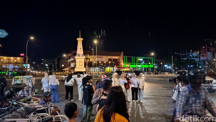 Wisatawan berswafoto di kawasan Tugu Pal Putih Jogja, Minggu (29/12/2024).