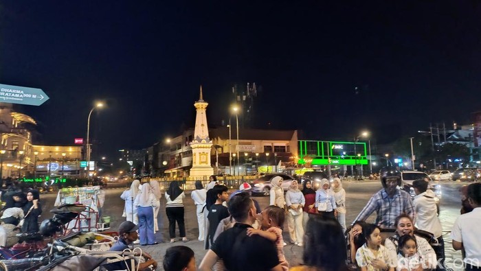 Wisatawan berswafoto di kawasan Tugu Pal Putih Jogja, Minggu (29/12/2024).