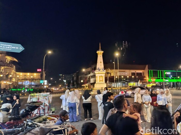 Wisatawan berswafoto di kawasan Tugu Pal Putih Jogja, Minggu (29/12/2024).