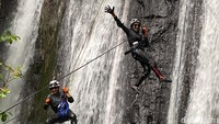 Warga melakukan canyoning di kawasan Gunung Menir, tepatnya di Curug Tebing, Desa Ciasmara.  