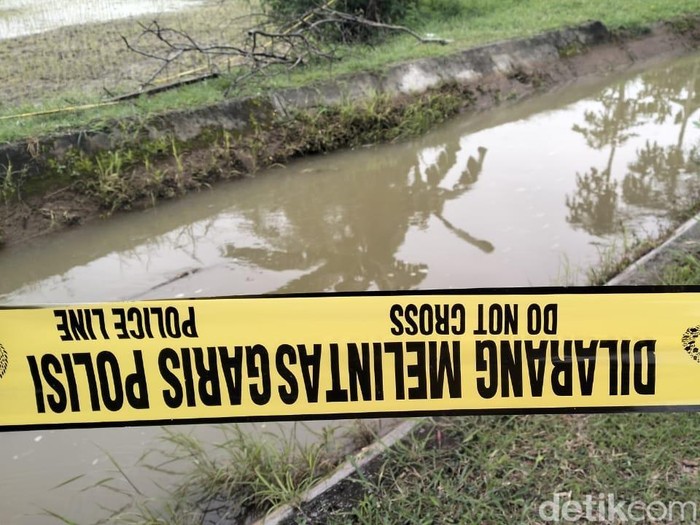 Garis polisi dipasang di lokasi penemuan mayat lelaki di saluran irigasi Desa Dalangan, Kecamatan Tawangsari, Kabupaten Sukoharjo, Senin (30/12/2024).