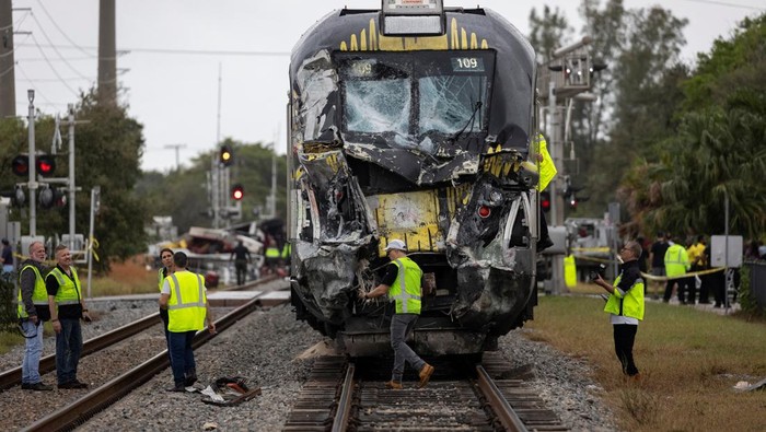 Delray Beach Police officers and Brighline personnel are seen at the scene after a Brightline passenger train collided with a fire truck on railtracks in Delray Beach, Florida, U.S. December 28, 2024.  REUTERS/Marco Bello