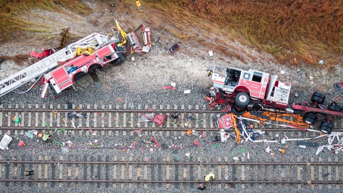 Delray Beach Police officers and Brighline personnel are seen at the scene after a Brightline passenger train collided with a fire truck on railtracks in Delray Beach, Florida, U.S. December 28, 2024.  REUTERS/Marco Bello