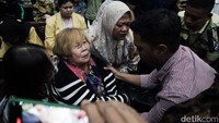 Tim kuasa hukum Helena dan petugas keamanan Pengadilan membawa keluar ibunda Helena menggunakan kursi roda.  
