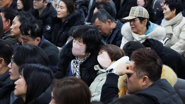 Keluarga penumpang pesawat yang jatuh setelah keluar landasan, berkumpul di Bandara Internasional Muan, di Muan, Korea Selatan, 29 Desember 2024. (REUTERS/Kim Hong-Ji)