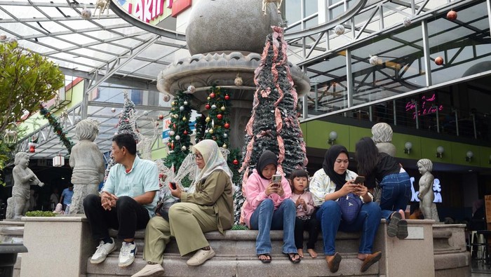 Sejumlah warga berjalan usai berbelanja di rest area 97 B di Kabupaten Purwakarta, Jawa Barat, Minggu (29/12/2024). Jasamarga menghimbau warga yang berhenti di rest area maksimal durasi 30 menit beristirahat pada libur Natal 2024 dan Tahun Baru 2025 untuk menghindari kepadatan kendaraan pemudik di lokasi itu. ANTARA FOTO/ Fakhri Hermansyah/YU