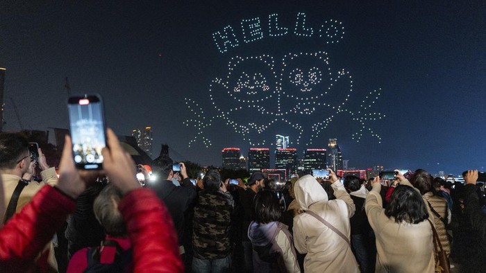 Meriahnya Pertunjukan Drone Panda Pertama di Hong Kong People watch the panda-themed drone show at the waterfront of the Victoria Harbour in Hong Kong, Saturday, Dec. 28, 2024. (AP Photo/Chan Long Hei)