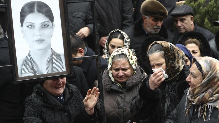 Momen Pilu Pemakaman Pilot dan Kru Pesawat Azerbaijan Airline People stand at the grave of pilot in command Igor Kshnyakin during a funeral of the crew members of the Azerbaijan Airlines Embraer 190 killed in a deadly plane crash in Kazakhstan this week, at the II Alley of Honor in Baku, Azerbaijan, Sunday, Dec. 29, 2024. (AP photo)