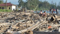 Warga berada diantara material sampah sisa abrasi di pantai Pekik Nyari, Kabupaten Bengkulu Tengah, Bengkulu, Sabtu (28/12/2024).
