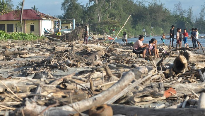 Warga berada diantara material sampah sisa abrasi di pantai Pekik Nyari, Kabupaten Bengkulu Tengah, Bengkulu, Sabtu (28/12/2024). Sampah kiriman berupa kayu dan plastik  yang berserakan di pesisir pantai sejak tiga bulan terakhir membuat beberapa kapal nelayan rusak dan sulit saat memarkir perahu usai melaut . ANTARA FOTO/Muhammad Izfaldi/foc.