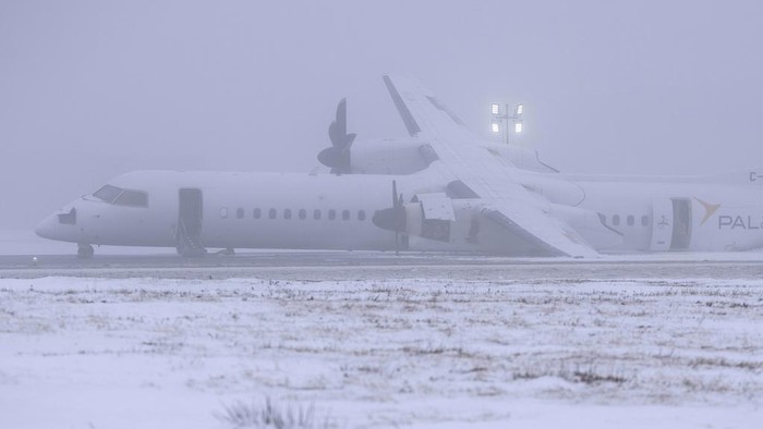 Penampakan Pesawat Air Canada yang Terbakar Saat Mendarat Darurat An Air Canada Express flight operated by Pal Airlines skidded off the runway Saturday night after catching fire at Halifax Stanfield International Airport is seen on Sunday, Dec. 29, 2024, in Halifax, Nova Scotia. (Darren Calabrese/The Canadian Press via AP)