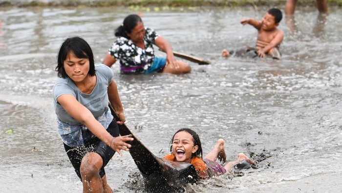Promosi wisata pedesaan di Bali Warga mengikuti lomba permainan tradisional tarik pelepah pinang di area persawahan Desa Suwat, Gianyar, Bali, Senin (30/12/2024). Kegiatan rangkaian Festival Air Suwat 2024 tersebut diselenggarakan untuk mempromosikan berbagai potensi pariwisata dan seni budaya yang ada di kawasan itu kepada para wisatawan sekaligus untuk melestarikan permainan tradisional. ANTARA FOTO/Fikri Yusuf/rwa.