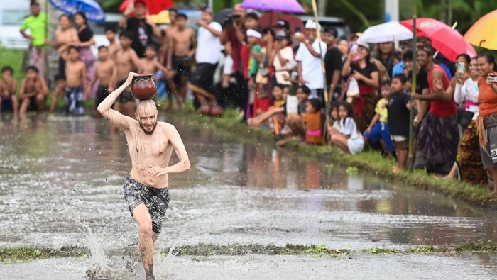 Warga mengikuti lomba permainan tradisional tarik pelepah pinang di area persawahan Desa Suwat, Gianyar, Bali, Senin (30/12/2024). Kegiatan rangkaian Festival Air Suwat 2024 tersebut diselenggarakan untuk mempromosikan berbagai potensi pariwisata dan seni budaya yang ada di kawasan itu kepada para wisatawan sekaligus untuk melestarikan permainan tradisional. ANTARA FOTO/Fikri Yusuf/rwa.