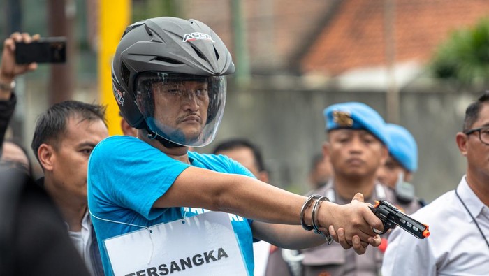 Pelaku penembak pelajar hingga tewas, Aipda Robig Zainudin (tengah) menunjukkan titik lokasi penembakan kepada personel kepolisian dalam rekonstruksi kasus penembakan di Kelurahan Kalipancur, Kecamatan Ngaliyan, Kota Semarang, Jawa Tengah, Senin (30/12/2024). Ditreskrimum Polda Jateng menggelar 43 adegan rekonstruksi di enam lokasi kejadian dengan menghadirkan Aipda Robig Zainudin sebagai tersangka penembakan dan 11 saksi termasuk almarhum GRO dan satu saksi lain berinisial B yang perannya digantikan, untuk mendapatkan gambaran utuh dari peristiwa penembakan tersebut. ANTARA FOTO/Aji Styawan/rwa.