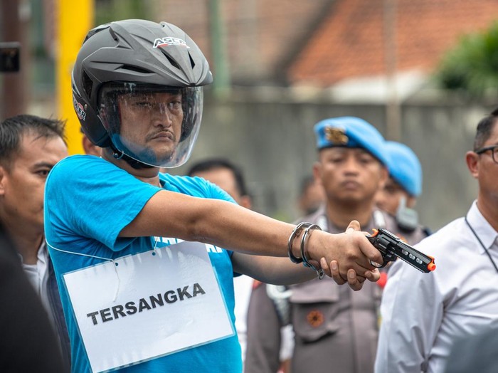 Pelaku penembak pelajar hingga tewas, Aipda Robig Zainudin (tengah) menunjukkan titik lokasi penembakan kepada personel kepolisian dalam rekonstruksi kasus penembakan di Kelurahan Kalipancur, Kecamatan Ngaliyan, Kota Semarang, Jawa Tengah, Senin (30/12/2024). Ditreskrimum Polda Jateng menggelar 43 adegan rekonstruksi di enam lokasi kejadian dengan menghadirkan Aipda Robig Zainudin sebagai tersangka penembakan dan 11 saksi termasuk almarhum GRO dan satu saksi lain berinisial B yang perannya digantikan, untuk mendapatkan gambaran utuh dari peristiwa penembakan tersebut. ANTARA FOTO/Aji Styawan/rwa.