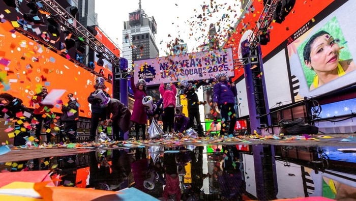 People celebrate while organizers of the upcoming ball drop on New Year's Eve do a confetti test in Times Square, New York, U.S., December 29, 2024. REUTERS/Eduardo Munoz