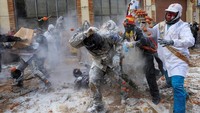 Para penikmat yang dikenal sebagai ‘Els Enfarinats’ (mereka yang diselimuti tepung) menggelar kudeta pura-pura yang berantakan di kota Ibi, Spanyol, pada hari Sabtu (28/12), menggunakan tepung dan telur sebagai senjata mereka.