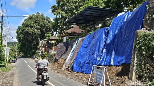 Tembok pembatas SMPN 2 Dawan di Desa Gunaksa, Klungkung, ditutup terpal pasca longsor beberapa waktu lalu, Senin (30/12/2024). (Putu Krista/detikBali)