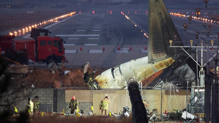 Boeing Kirim Tim untuk Selidiki Kecelakaan Jeju Air Rescuers work near the wreckage of the Jeju Air aircraft that went off the runway and crashed at Muan International Airport, in Muan, South Korea, December 30, 2024. REUTERS/Kim Hong-Ji TPX IMAGES OF THE DAY