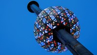 Berdiri di panggung luar ruangan yang tinggi di atas Times Square, perwakilan dari Countdown Entertainment, Times Square Alliance, Jamestown, dan 1 Times Square menyalakan sakelar untuk menyalakan dan mengangkat bola kristal Times Square seberat 11.875 pon untuk Malam Tahun Baru.  