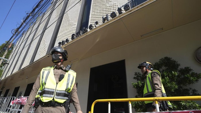 Policemen stand guard after a hotel fire in Bangkok, Thailand, Monday, Dec. 30, 2024. (AP Photo/Sakchai Lalit)