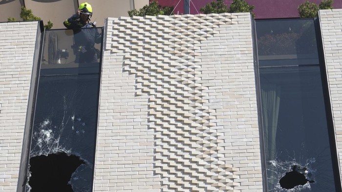 Policemen stand guard after a hotel fire in Bangkok, Thailand, Monday, Dec. 30, 2024. (AP Photo/Sakchai Lalit)