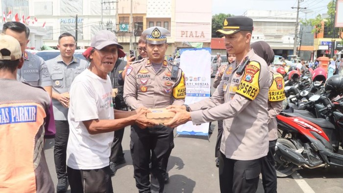 Kapolres Pasuruan Kota AKBP Davis Busin Siswara mmbagikan makanan bergizi gratis ke tukang becak