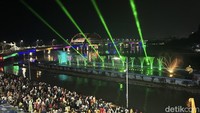 Laser air mancur di Jembatan Suroboyo rupanya dinyalakan lebih awal pada pukul 22.30 WIB sembari menunggu momen pergantian tahun.