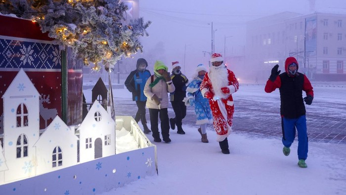 Lomba Lari Malam Tahun Baru di Kota Terdingin Dunia Participants of the New Year's Eve race run gather near a Christmas tree, after the temperature went below minus 47 degrees Celsius (minus 52.6 degrees Fahrenheit) in Yakutsk, the capital of the Sakha Republic located in the northeastern part of Siberia, Russia, December 31, 2024. REUTERS/Vadim Skryabin