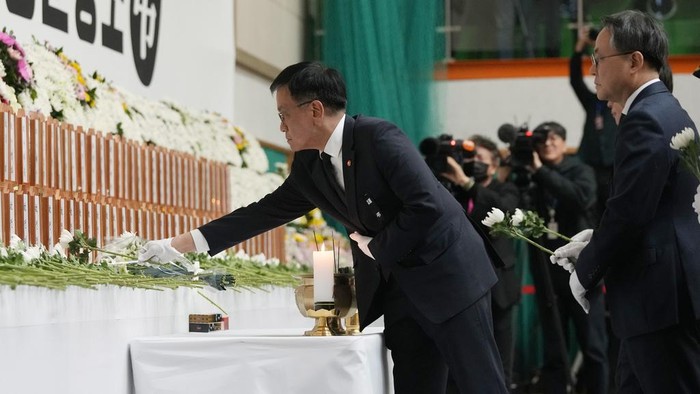 South Korea's acting President Choi Sang-mok places a flower for the victims on a plane which skidded off a runway and burst into flames, at a memorial altar at Muan sport park in Muan, South Korea, Monday, Dec. 30, 2024. (AP Photo/Ahn Young-joon)