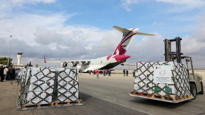 People stand near a plane carrying aid from Qatar, as it arrives at Damascus International Airport, Syria, December 30, 2024. REUTERS/Yamam al Shaar