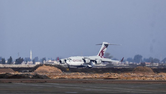 Pesawat Bantuan Qatar Tiba di Damaskus Suriah People stand near a plane carrying aid from Qatar, as it arrives at Damascus International Airport, Syria, December 30, 2024. REUTERS/Yamam al Shaar