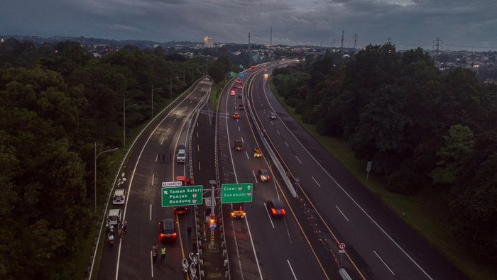Petugas kepolisian melakukan penutupan jalur di pintu keluar tol Gadog, Ciawi, Kabupaten Bogor, Jawa Barat, Selasa (31/12/2024). Satuan Lantas Polres Bogor memberlakukan malam bebas kendaraan bermotor atau car free night (CFN) di jalur wisata Puncak mulai pukul 18.00 WIB (31/12/2024) hingga pukul 06.00 WIB (1/1/2025) guna mencegah penumpukan kendaraan pada malam pergantian tahun. ANTARA FOTO/Yulius Satria Wijaya/aww.