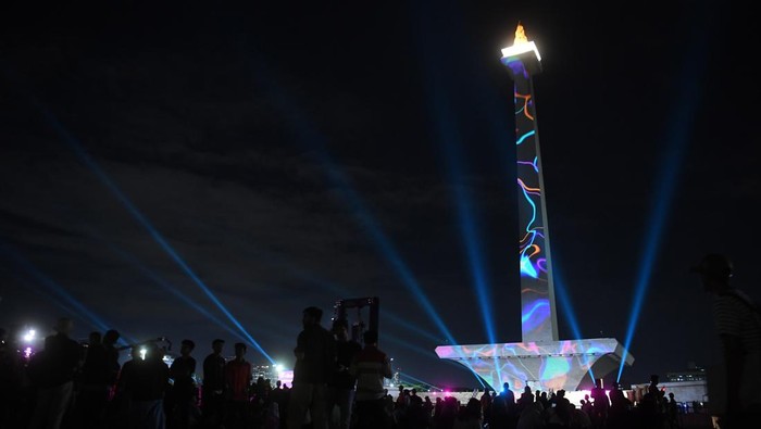 Warga menyaksikan pertunjukan air mancur menari saat peringatan tahun baru 2025 di Monas, Jakarta, Selasa (31/12/2024). Untuk memeriahkan malam pergantian tahun 2025 pengelola Monas menampilkan video mapping, air mancur menari hingga panggung hiburan. ANTARA FOTO/Akbar Nugroho Gumay