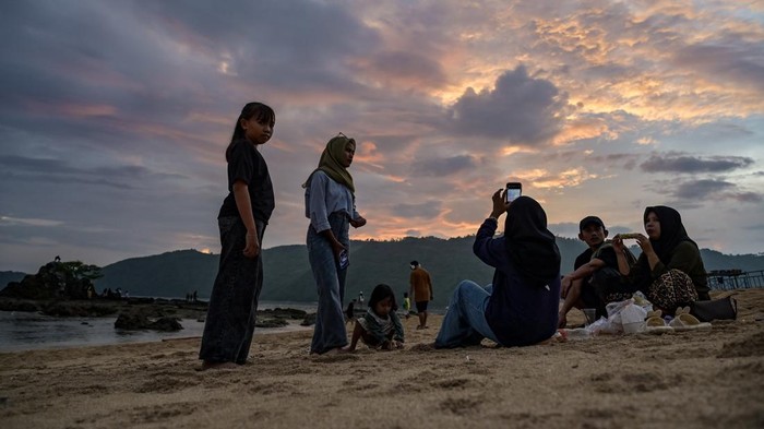 Pengunjung berada dipinggiran pantai saat matahari terbenam (sunset) akhir tahun 2024 di Pantai Mandalika, KEK Mandalika, Kuta, Praya, Lombok Tengah, NTB, Selasa (31/12/2024). Menikmati sunset akhir tahun di pinggir pantai menjadi salah satu alternatif sebagian warga untuk melewati pergantian tahun 2024 di Lombok. ANTARA FOTO/Ahmad Subaidi/foc.